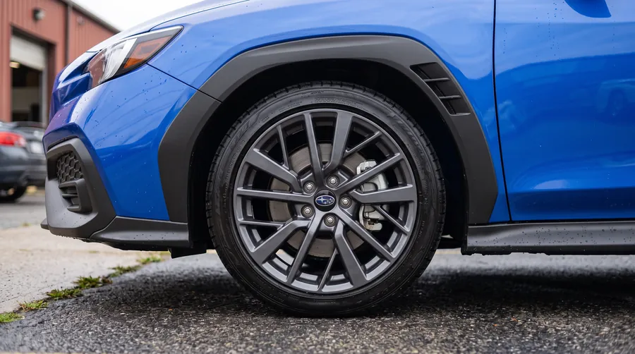 Clean wheel and dressed tire on a blue Subaru WRX